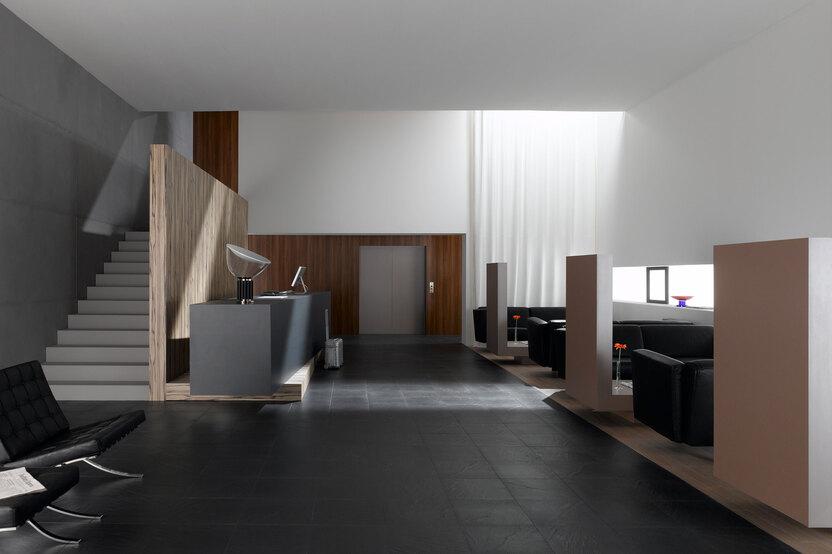 Hotelappartment Untergeschoss mit Holzmobiliar Hotelappartment Untergeschoss mit Holzmobiliar, dunklem Parkett und Treppenaufstieg