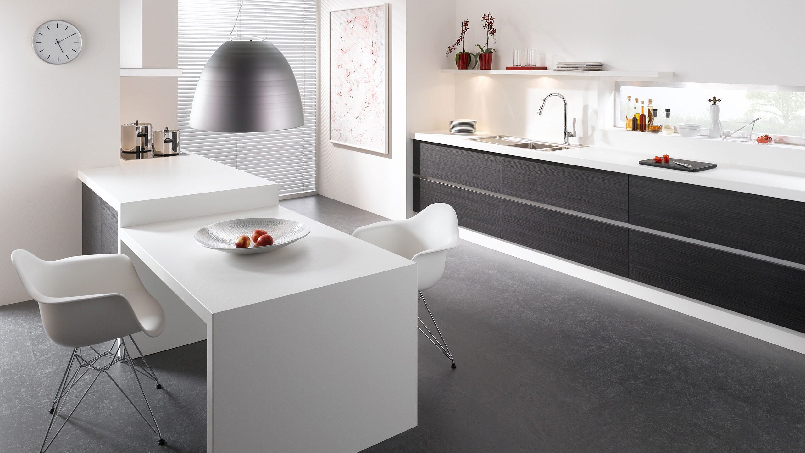Impression einer einzeiligen Küchengestaltung in schwarz-weiß mit Esstisch für Zwei