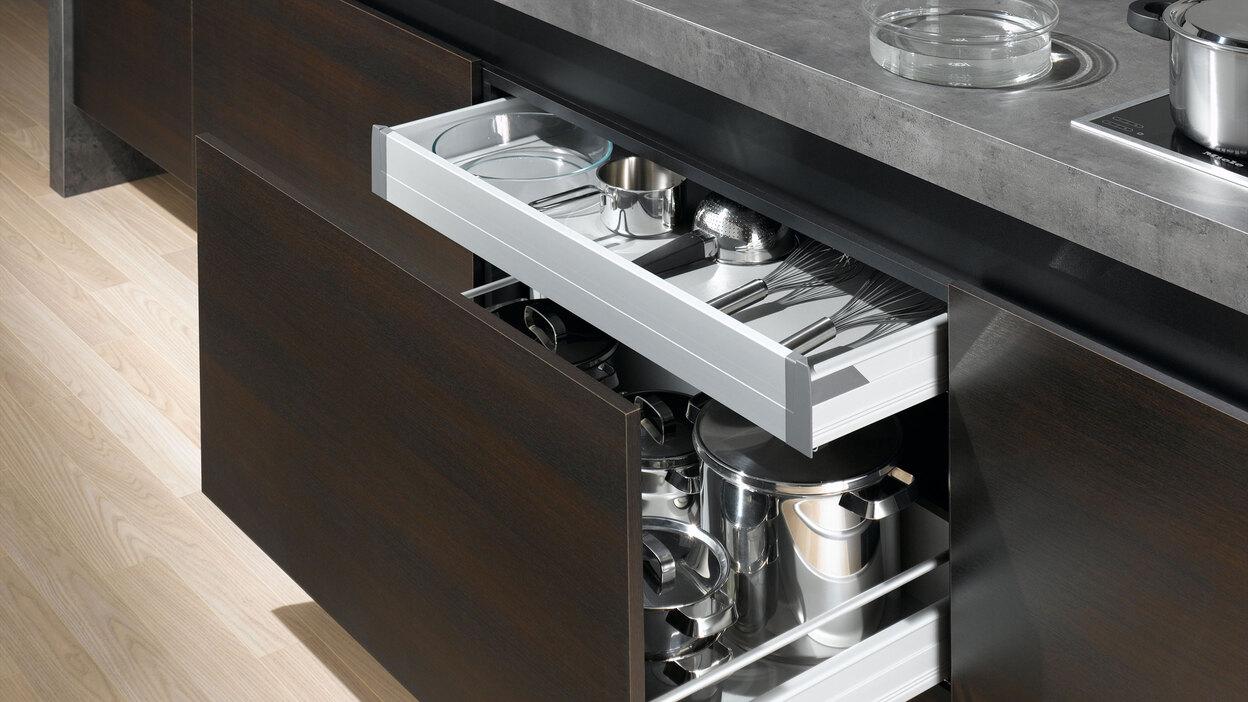 Detailaufnahme von Küchenschubladen mit viel Stauraum in dunklem Holz