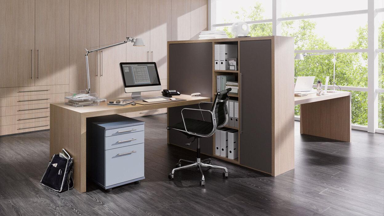 Impression von freistehenden Büromöbeln in L-Form mit hellem Einbauschrank im Hintergrund