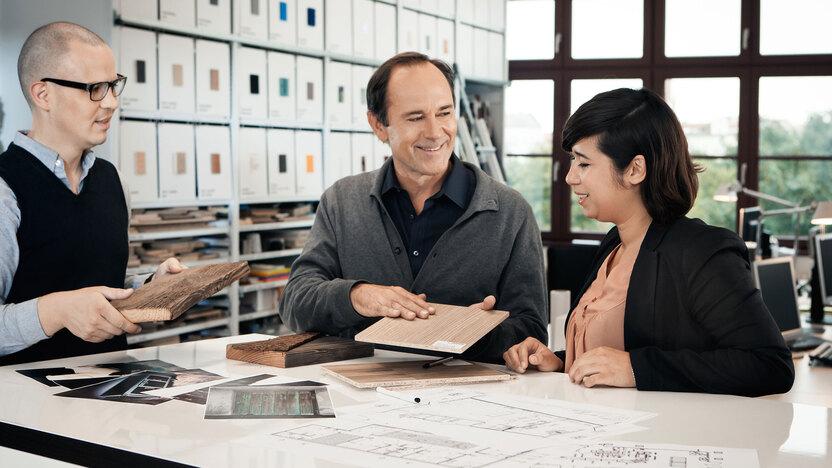 Beratung zu verschiedenen Holzoberflächen zwischen Berater und Eheleuten