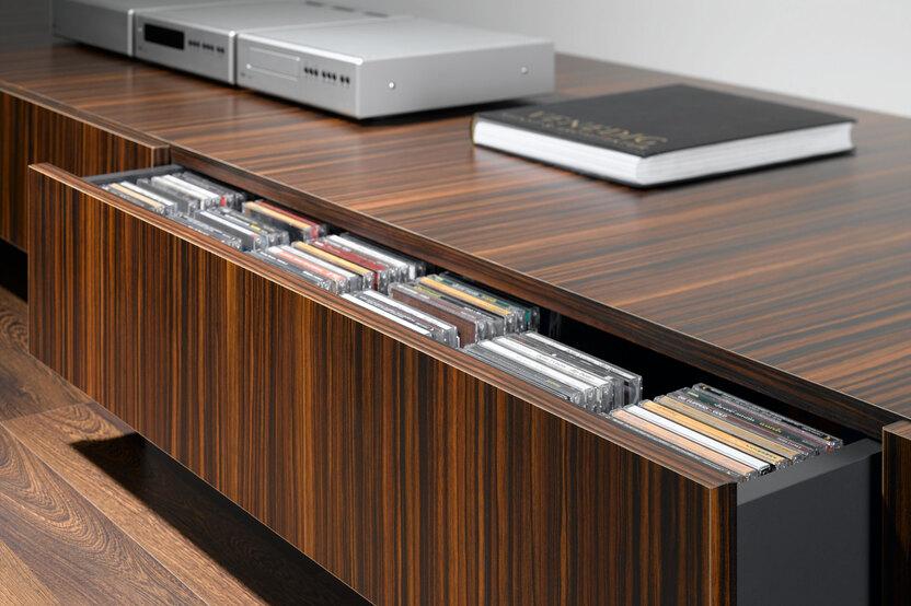 Detailaufnahme eines Sideboards mit Schublade Detailaufnahme eines lackierten Sideboards mit offener Schublade für CD-Aufbewahrung