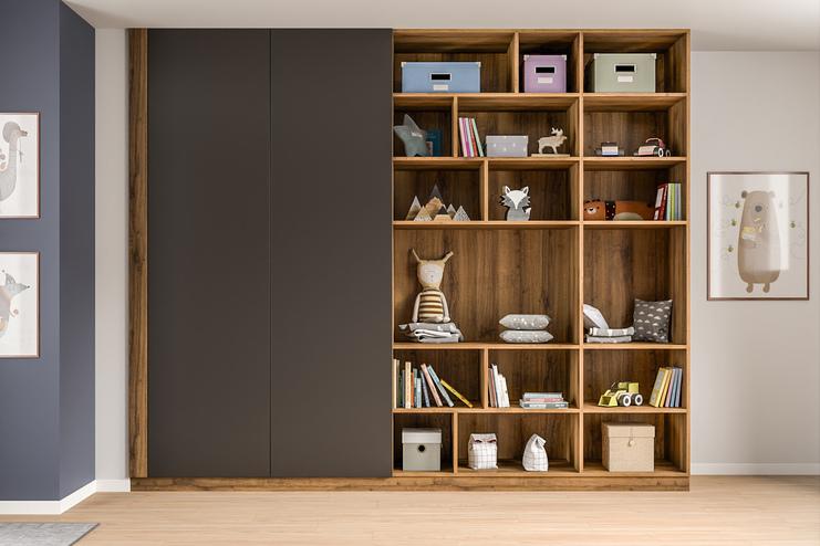 Eleganter, dunkler Schrank nach Maß neben einem offenen Regal mit Spielzeug und Büchern, harmonisch in das Ambiente eines Kinderzimmers eingefügt.