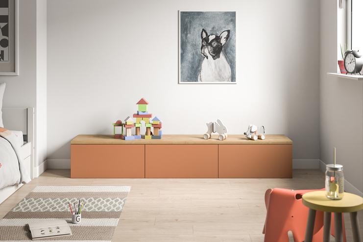 Eine moderne, terrakottafarbene Kommode nach Maß bietet mit ihrer glatten Oberfläche und geräumigen Schubladen einen kindgerechten Stauraum im Zimmer.