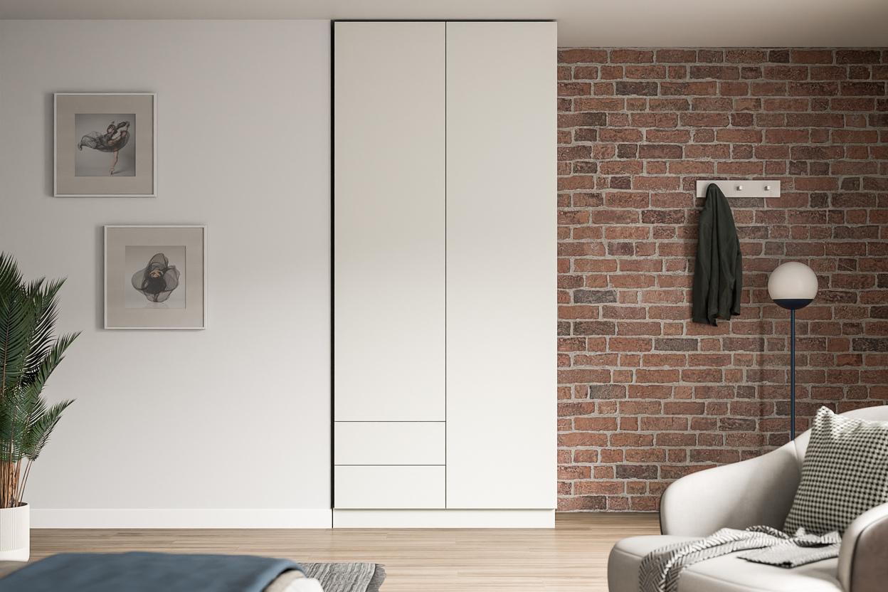 Großer, maßgeschneiderter weißer Schrank im Kontrast zu einer Ziegelwand, neben Kunstwerken und einer stilvollen Stehlampe.