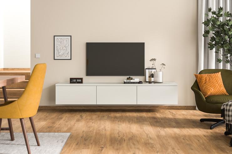Ein maßangefertigtes, wandmontiertes Hängeboard in schlichtem Weiß unter einem Wandfernseher, ergänzt durch zeitgenössische Deko und Grünpflanzen, fügt sich nahtlos in ein modernes Wohnambiente ein.