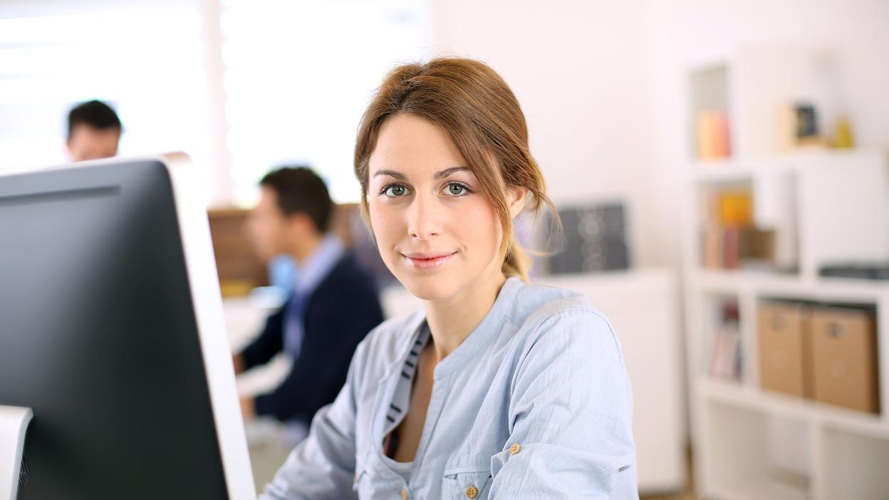 Mitarbeiterin am Schreibtisch Mitarbeiterin am Schreibtisch